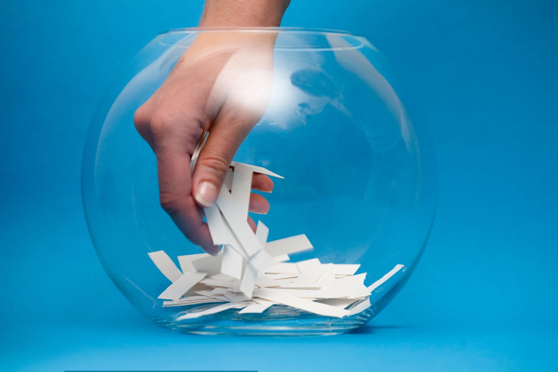 pulling paper out of a bowl