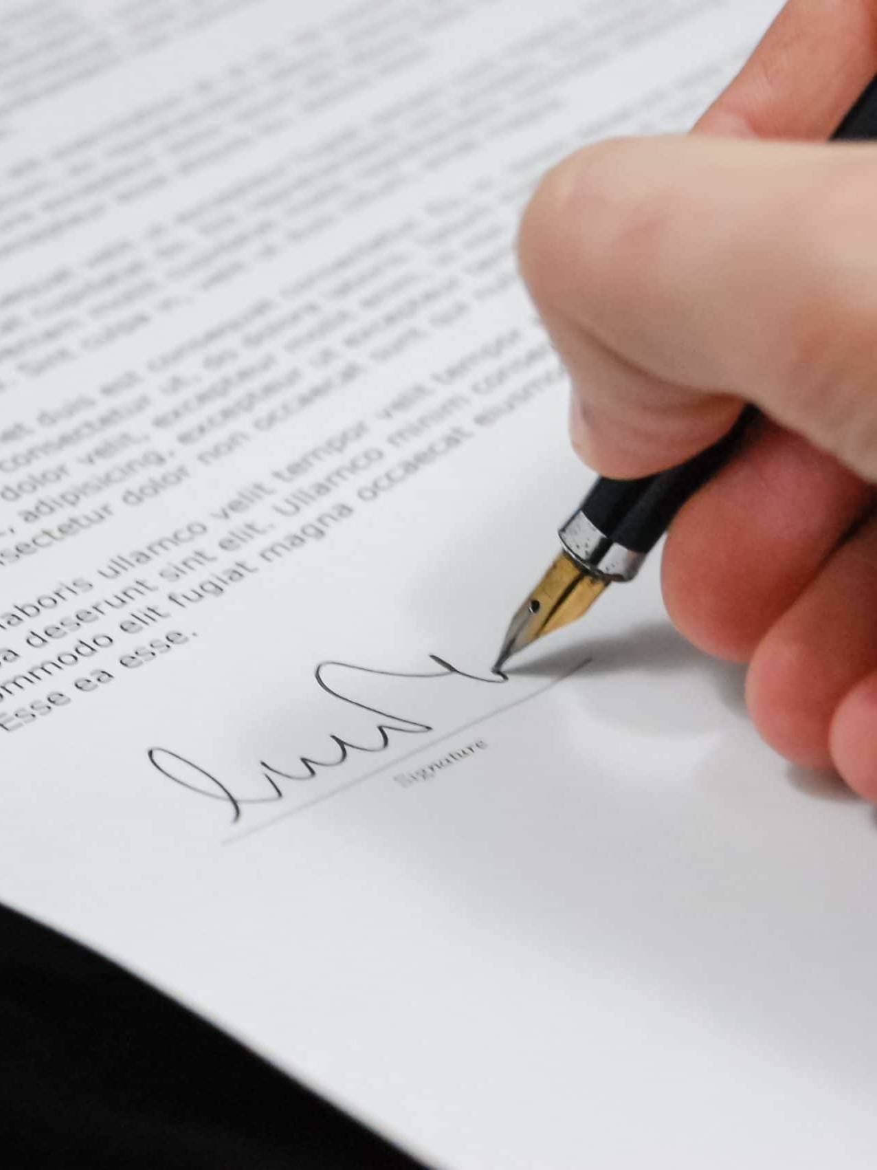 a hand signing a document