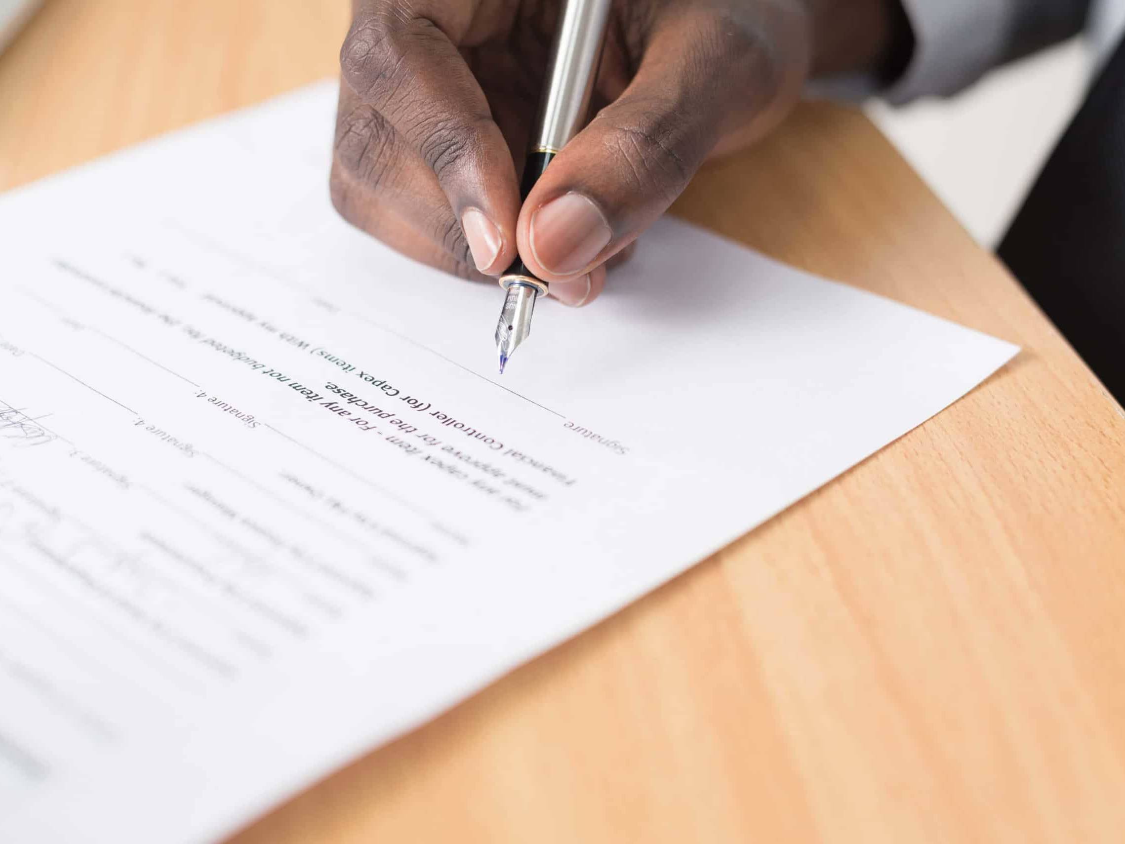 a hand signing a contract