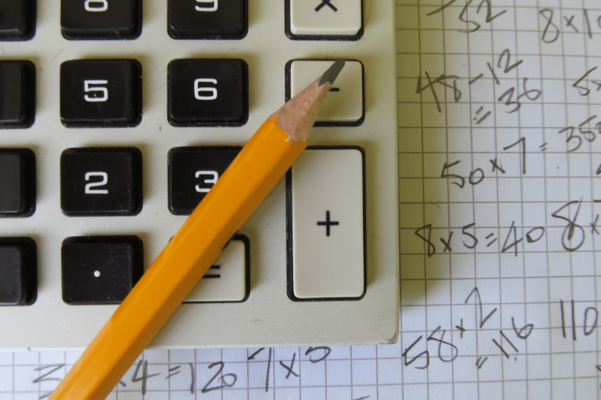 calculator and pencil on paper with calculations