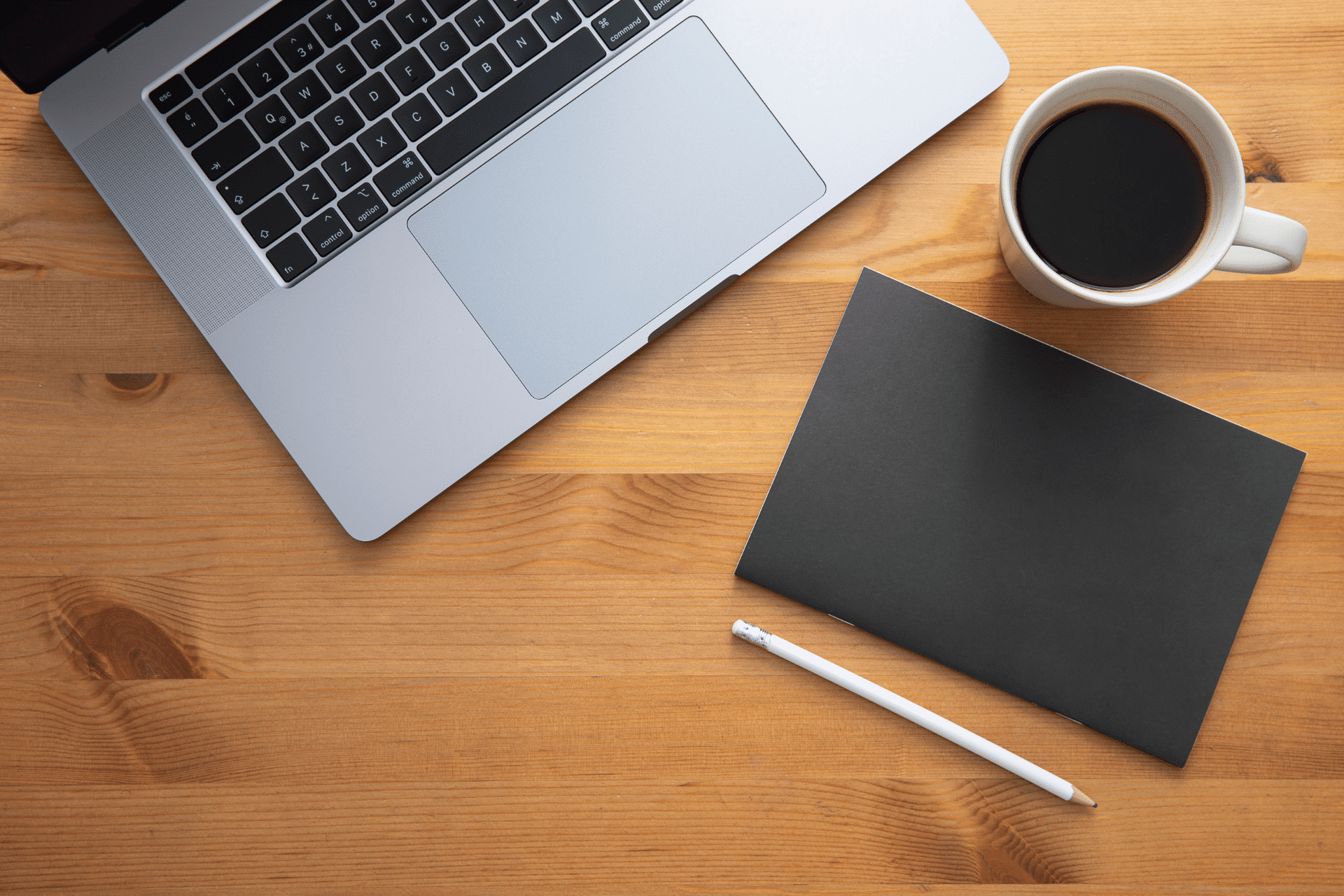 open laptop on a desk with a cup of coffee